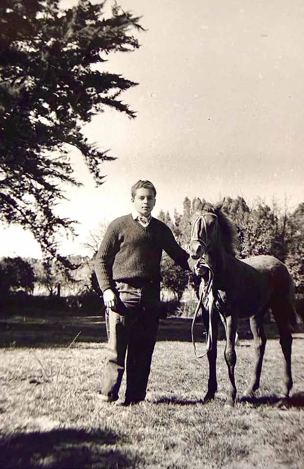 Foto antigua en blanco y negro de un joven de la familia Ferro junto a un potrillo