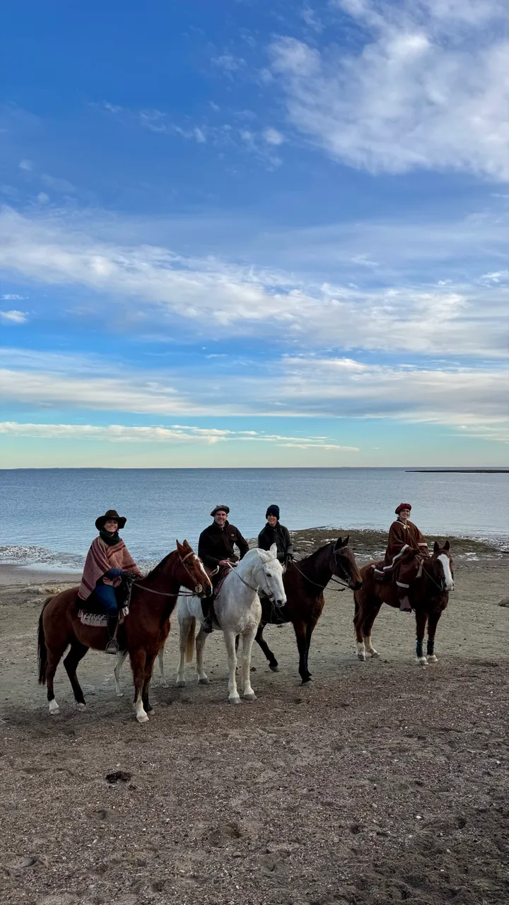 Cuatro jinetes alineados en la playa de Punta Pardelas con el mar de fondo
