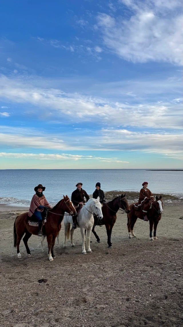 Cuatro jinetes alineados en la playa de Punta Pardelas con el mar de fondo